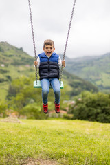 Swinging child on the middle of a field