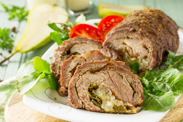 Stuffed Meat close-up Roll with Pear and Cheese on a festive Thanksgiving Day table.