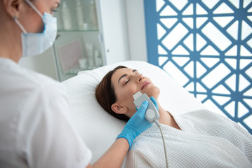 Lady on suprasonic cleaning procedure of face