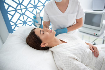Female enjoying of beauty procedure of face