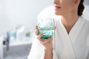 Young female with glass of water in spa center