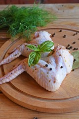 Raw chicken wings with spices and herbs on a wooden Board for grilling.