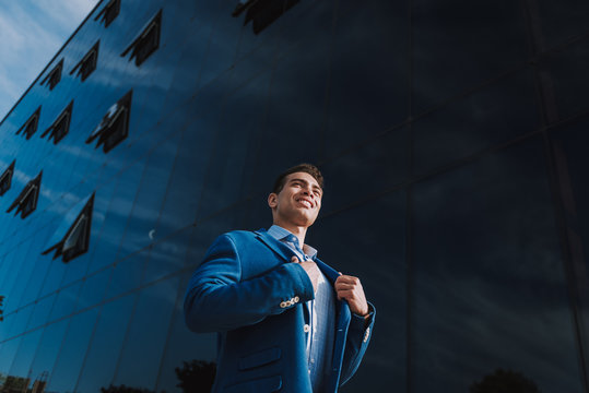Cheerful executive near modern business center outdoors