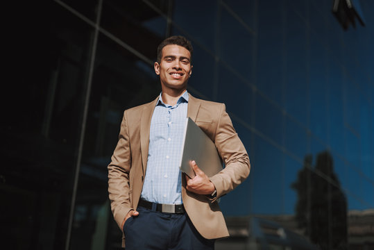 Cheerful man is going to work with notebook