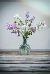 Field flowers in a glass vase isolated on white