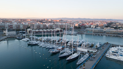 Fototapeta na wymiar Aerial view of the pier with yachts and boats in the city of Valencia, Spain. Drone photography.