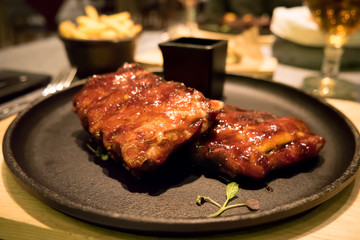 Pork ribs on a black plate