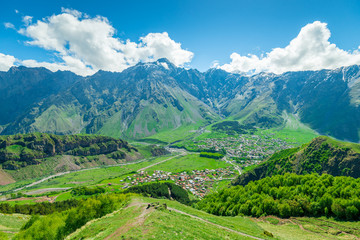 Fototapeta na wymiar The village of Gergeti in the valley of the Caucasus in Georgia against the backdrop of high beautiful mountains