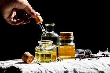 Obraz na płótnie Canvas Pure black pepper essential oil by hand dripping - a concept for good health