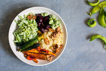 Buddha bowl with roast beetroots, carrots, zucchini and green peas salad