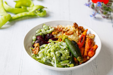 Buddha bowl with roast beetroots, carrots, zucchini and green peas salad