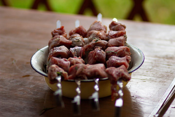 Delicious fried pork kebab strung on skewers on the table in the gazebo