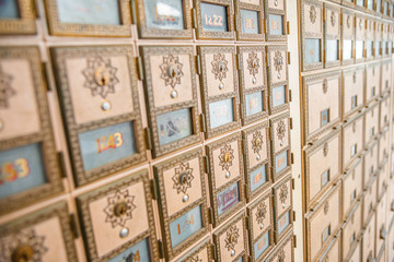 Rows of mid-century modern design post office mailboxes in brass metal.