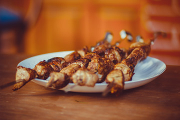 Delicious fried pork kebab strung on skewers on the table in the gazebo
