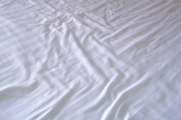 Perspective view white stripe pattern clean and unmade bedsheet 