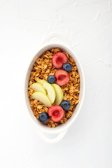 Healthy whole grain breakfast. Baked granola from oatmeal flakes in caramel with fresh berries and fruits of cherries, blueberries, nectarines, basil. Portion. Top view. Balanced diet.