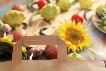 Bright fresh vegetables, fruits and flowers on a wooden table from the market package, healthy food, the season of summer and autumn