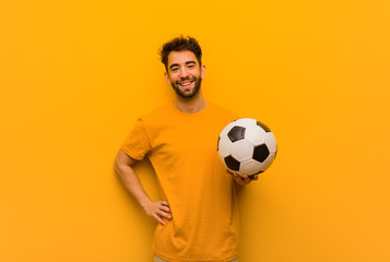 Young soccer player man with hands on hips