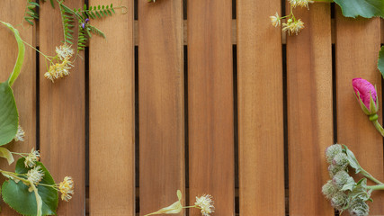 Table made of wooden planks decorated with linden flowers and buds of burdock and wild rose background with copy space
