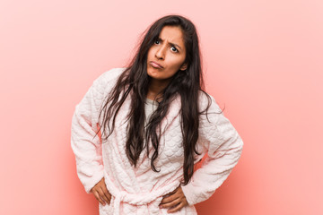 Fototapeta premium Young indian woman wearing pajama scolding someone very angry.