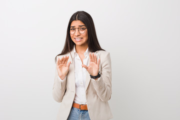 Young business arab woman isolated against a white background rejecting someone showing a gesture...