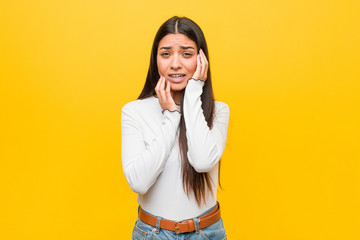 Young pretty arab woman against a yellow background whining and crying disconsolately.