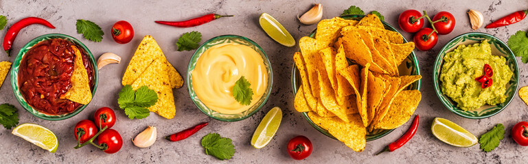 Mexican food background: guacamole, salsa, cheesy sauces with nachos