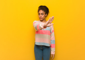 Young black african american girl with blue eyes putting hand in front