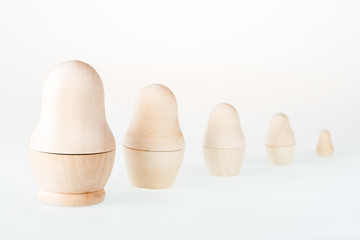 Clear wooden nesting dolls. Russian traditional toy, named matryoshka, on white background. Copy...