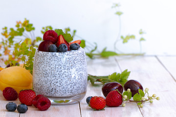 Chia seed pudding with berries on wooden table. rustic stile healthy Breakfast. Chia seed with milk, fruits and fresh berry. well being weight loss concept. yogurt drink, vitamin cocktail.