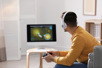 Young man playing video games at home © New Africa
