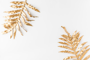 Gold tropical monstera leaves on white background. Flat lay, top view. Tropical plant backdrop