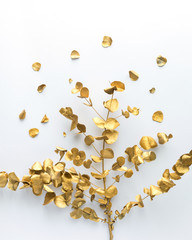 Golden tropical palm leaf on white background. Flat lay, top view. Minimal beauty fashion concept.