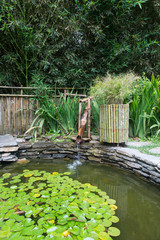 bamboo fountain with lagoon in zen nature park