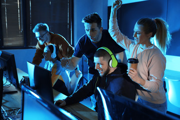 Group of people playing video games in internet cafe