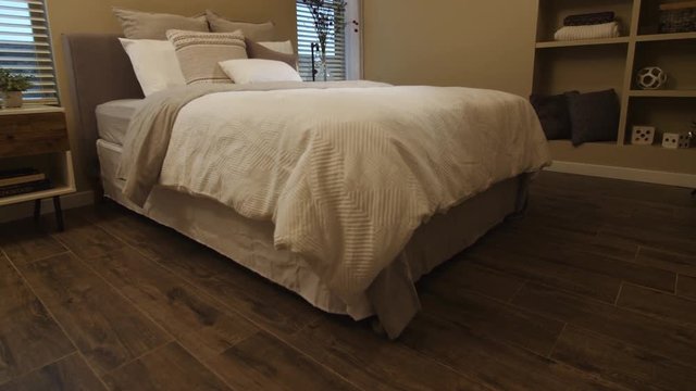 Rising Tan Bedroom from Hardwood Floors. view moves up from the hardwood tile floors to show a tan traditional bedroom