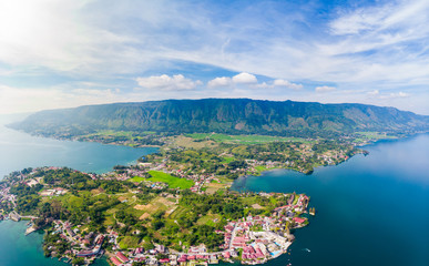 Aerial: lake Toba and Samosir Island view from above Sumatra Indonesia. Huge volcanic caldera covered by water, traditional Batak villages, green rice paddies, equatorial forest.