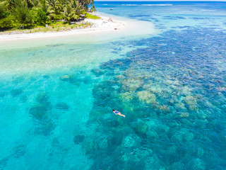 Aerial top down people snorkeling on coral reef tropical caribbean sea, turquoise blue water. Indonesia Banyak Islands Sumatra, tourist diving travel destination.