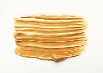 Stroke of gold paint isolated on white, top view