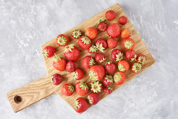 Strawberry berries on cutting board on the table, top view