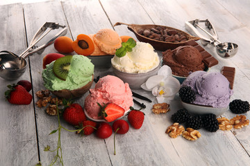 ice cream scoops of different colors and flavours with berries, nuts and fruits decoration on white background