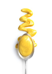 Delicious mustard and spoon on white background, top view. Spicy sauce