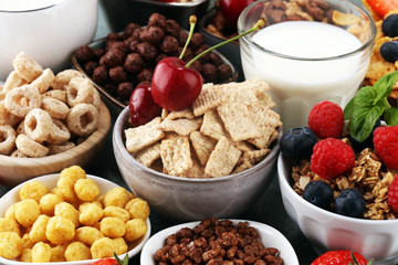 Cereal. Bowls of various cereals, berries and milk for breakfast. Muesli with kids cereals.