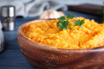 Bowl with mashed sweet potatoes on wooden table, closeup