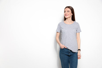Obraz premium Young woman in t-shirt on light background. Mock up for design