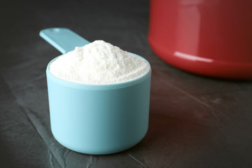 Scoop of protein powder on grey stone table