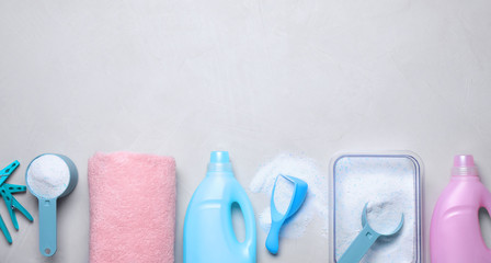 Flat lay composition with laundry detergent on light background, space for text