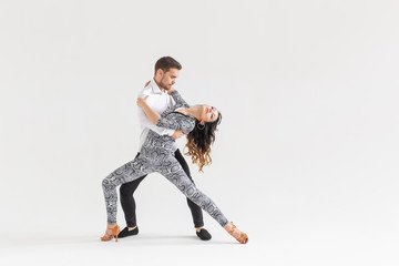 Social dance concept - Active happy adults dancing bachata together over white background with copy space