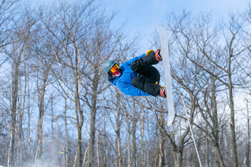 A snowboarder performs an aerial grab in a terrain park