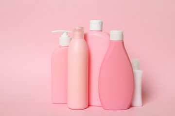 Different bottles of shampoo on pink background. Natural cosmetic products